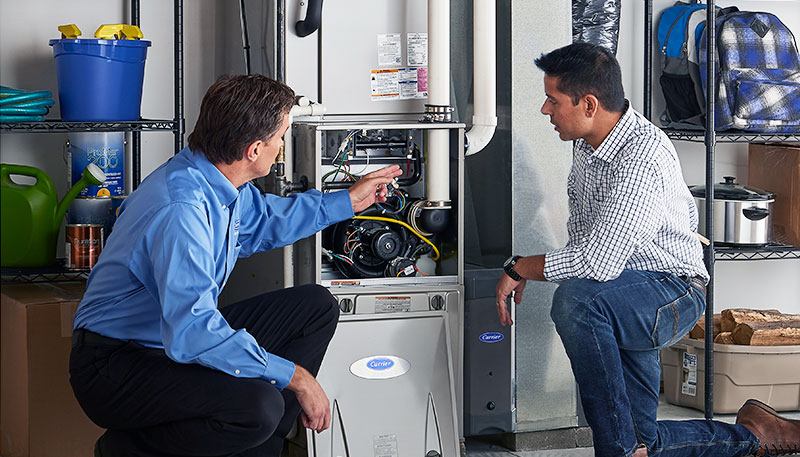 HVAC technician evaluating a furnace for repair or replacement in Evans