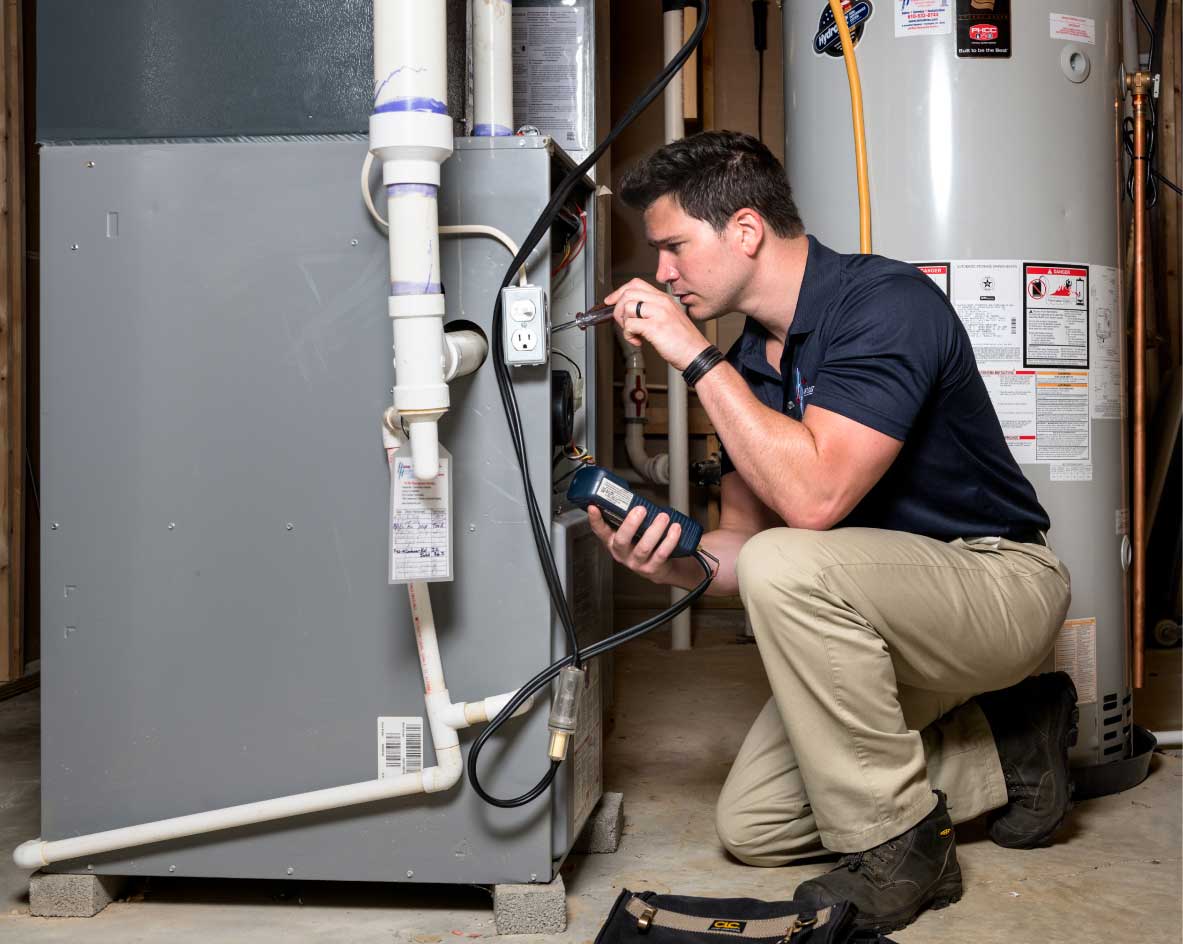 HVAC technician performing a furnace tune-up in Evans