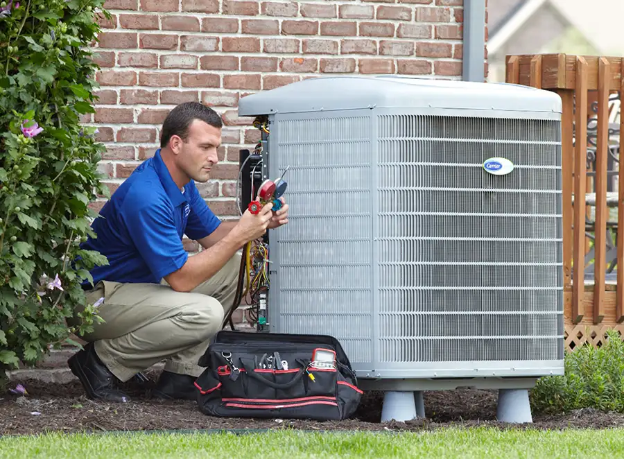 HVAC technician inspecting an outdoor air conditioning unit in Evans