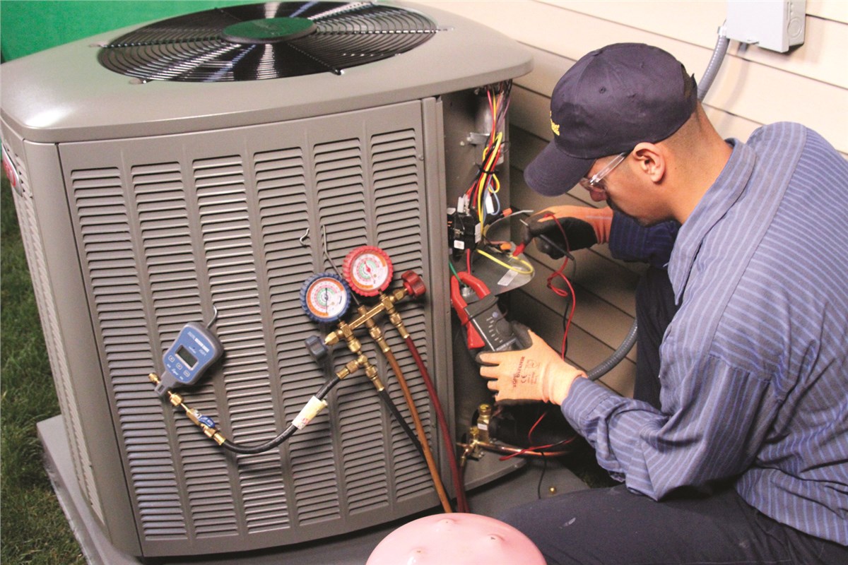 HVAC technician testing an outdoor air conditioning unit in Evans